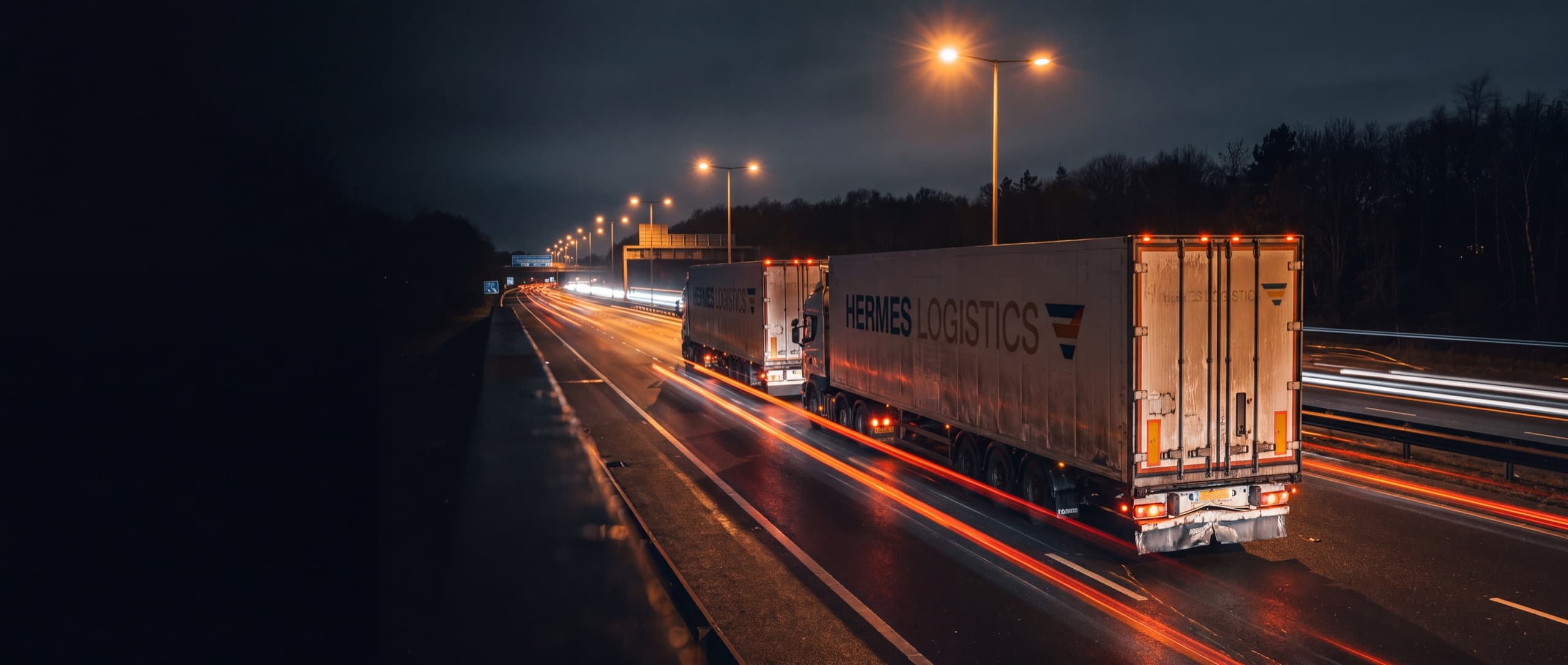Freight trucks on a highway at night.